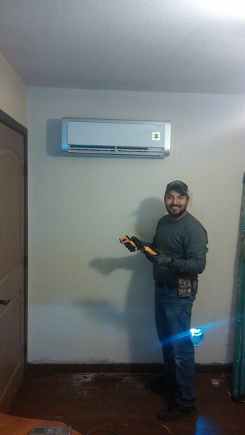 Technician mounting a ductless minisplit indoor unit